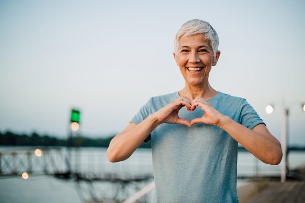 Active senior woman making a heart with her hands
